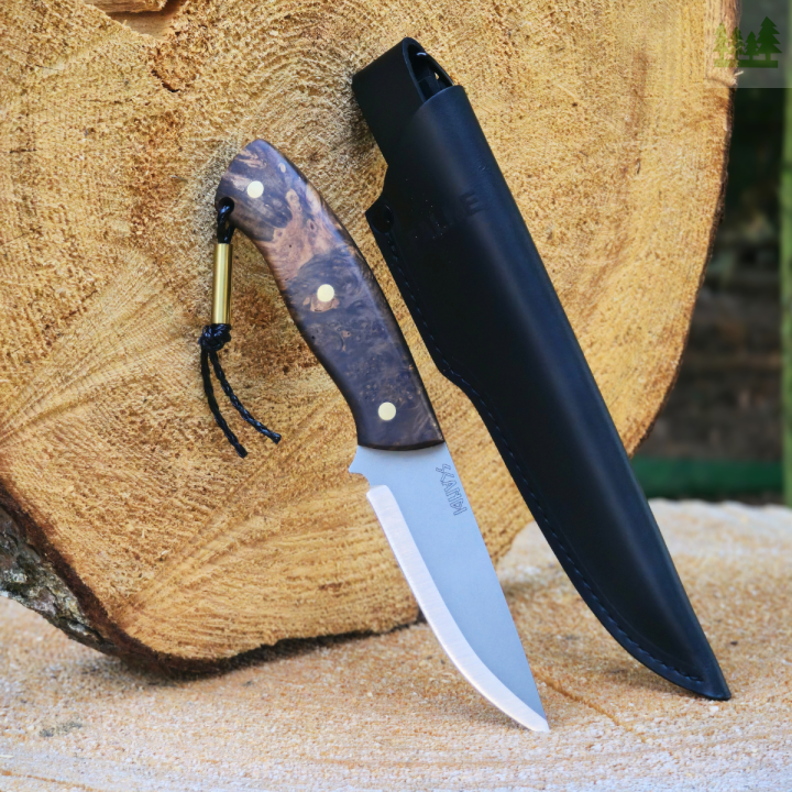 Nóż myśliwski Falke Scandi N690 na pieńku z czarną pochwą Ręcznie robiony nóż Falke Scandi ze stali N690, szlif skandynawski, wytrzymałe ostrze. Pokazany na drewnianym pieńku z czarną skórzaną pochwą, idealny do polowania i bushcraftu.
