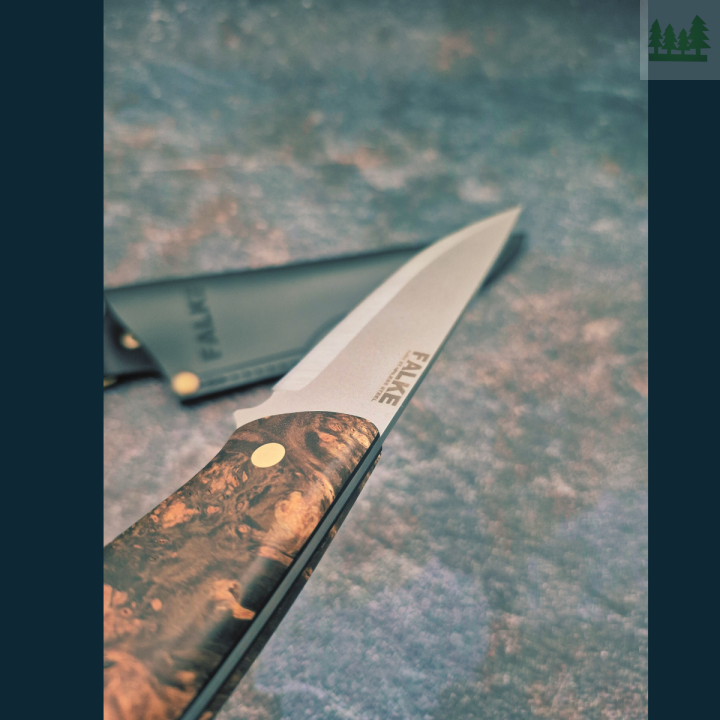 Zbliżenie na rękojeść Falke Scandi N690 Detal rękojeści noża Falke Scandi z czeczotu brzozy i G10, pokazujący ergonomiczny kształt, trwałość materiału i eleganckie wykończenie. 2