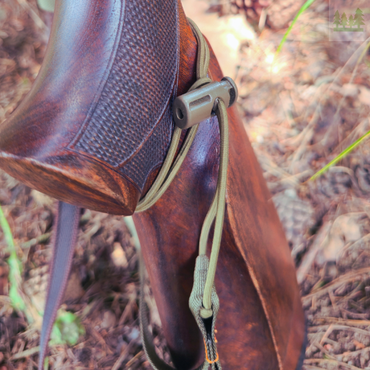 Pas myśliwski Wildspot HFB w otoczeniu lasu, poprawia bezpieczeństwo użytkowników broni. Zbliżenie na kolbe.